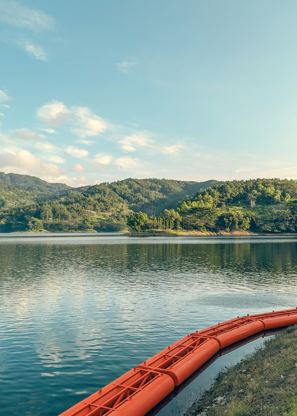 a red canoe sitting on the edge of a lake