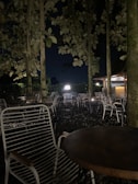 A serene outdoor seating area enveloped by greenery and subtle lighting at dusk.