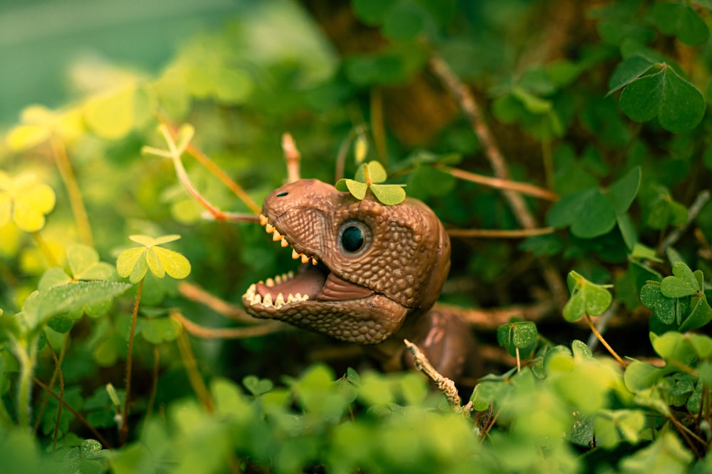 a close up of a toy dinosaur in a bush