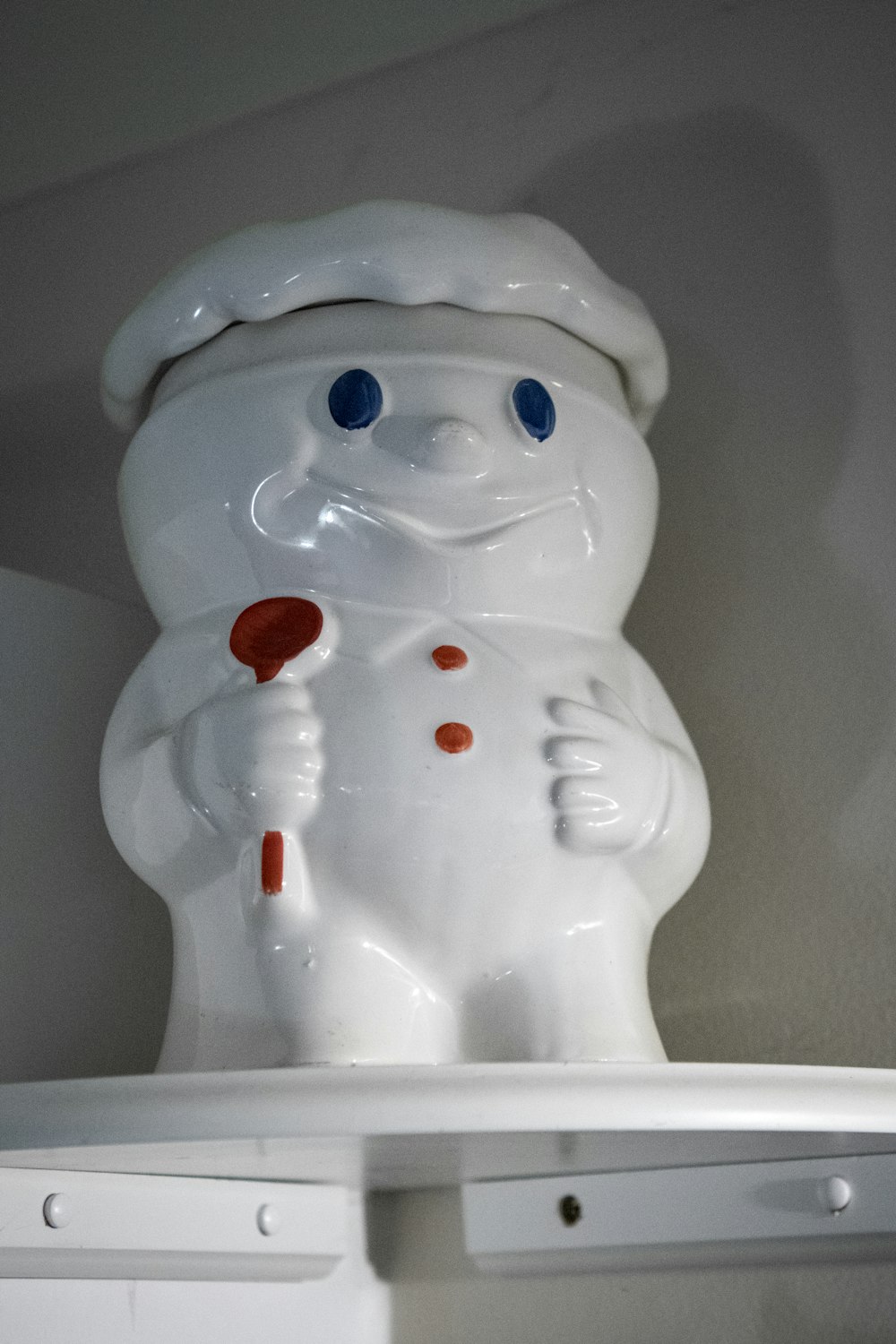 a white plastic snowman with blue eyes and a red nose