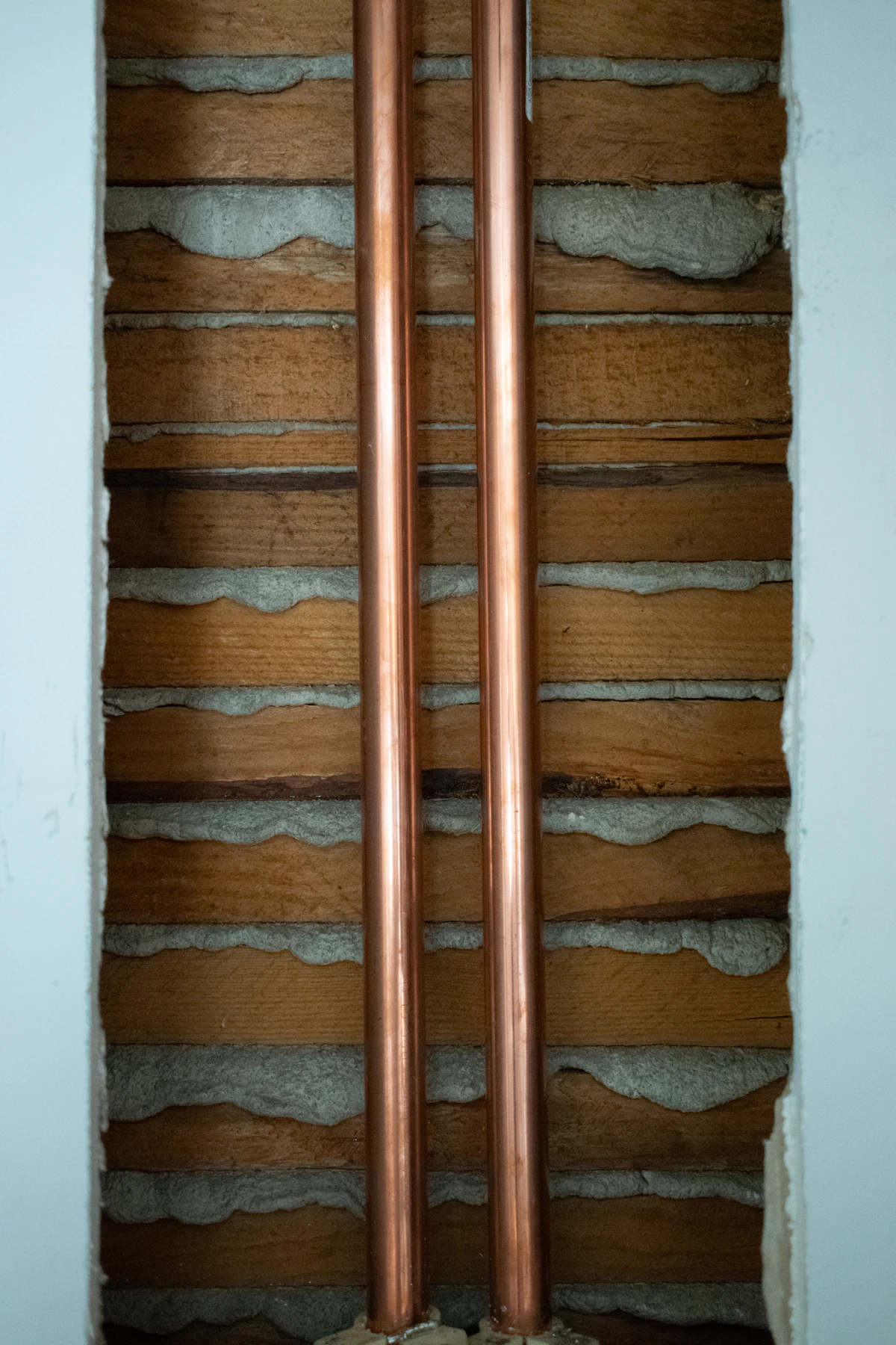 Galvanized supply out and copper in on a 1961 Woodbridge bungalow — one wall opened, patched before we left