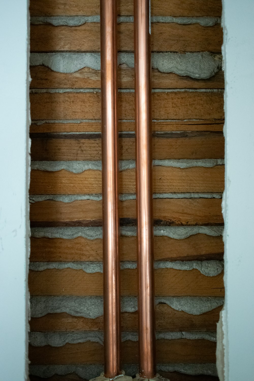a pair of copper pipes sitting on top of a wall
