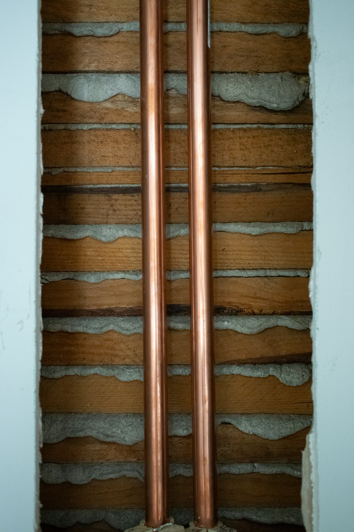 Two copper pipes mounted on a wall
