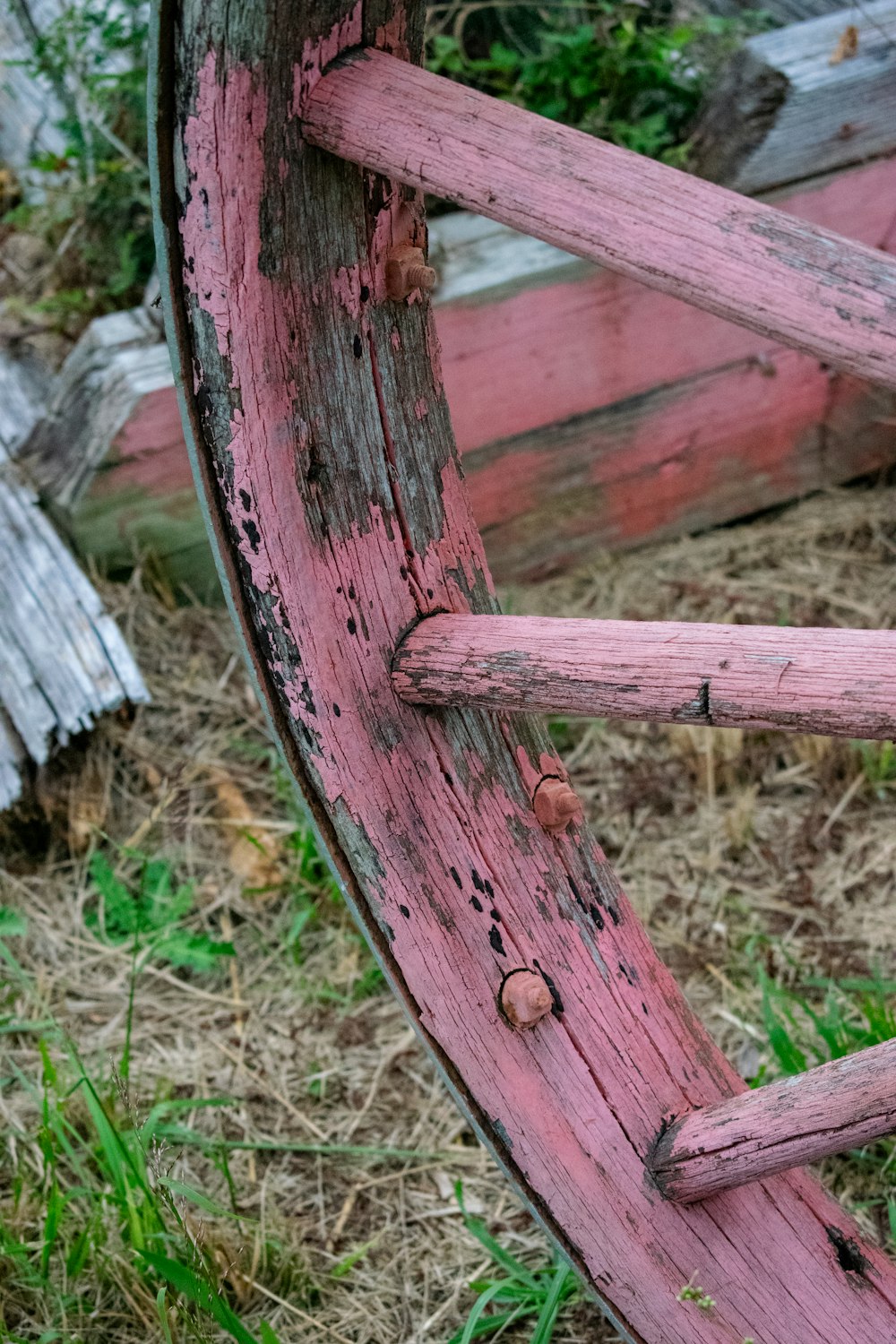 a close up of a wooden wheel on the ground