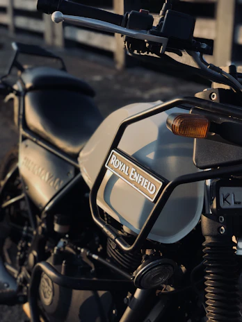 Close-up of a Royal Enfield bike’s polished chrome details gleaming under sunlight.