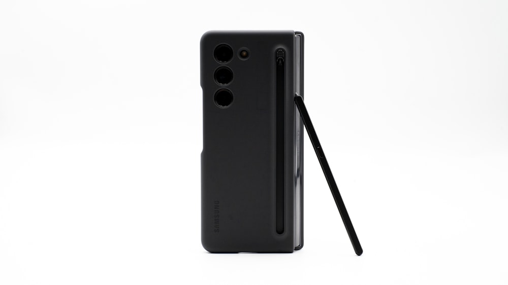 the back of a black cell phone with a black stick sticking out of it