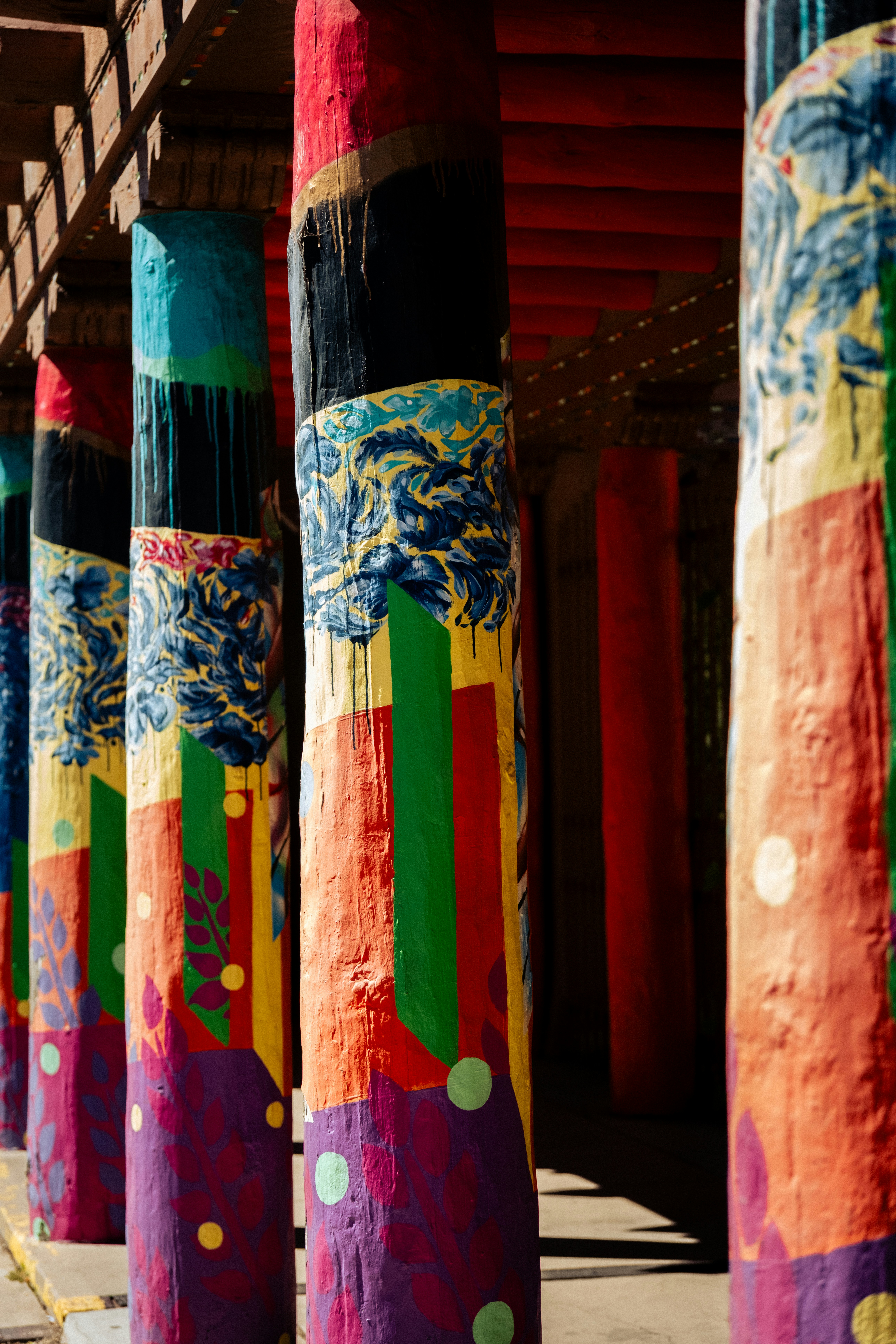 A row of painted poles sitting next to each other photo – Free Pillar