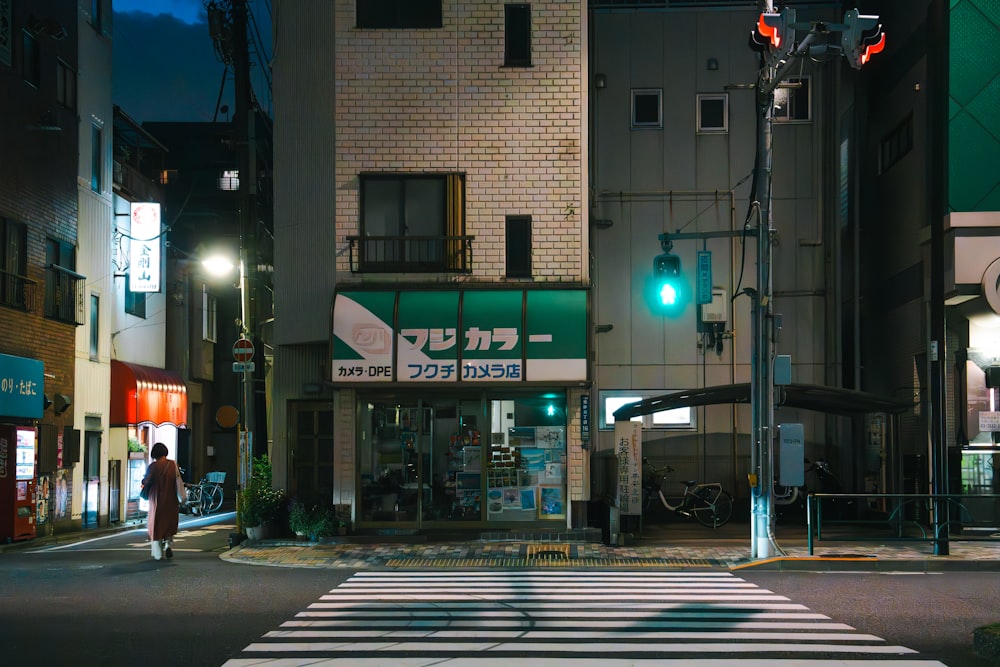 a person walking across a street at night