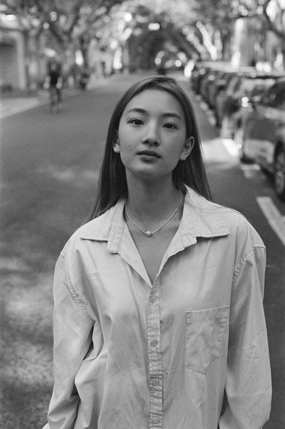 a black and white photo of a woman standing on a street