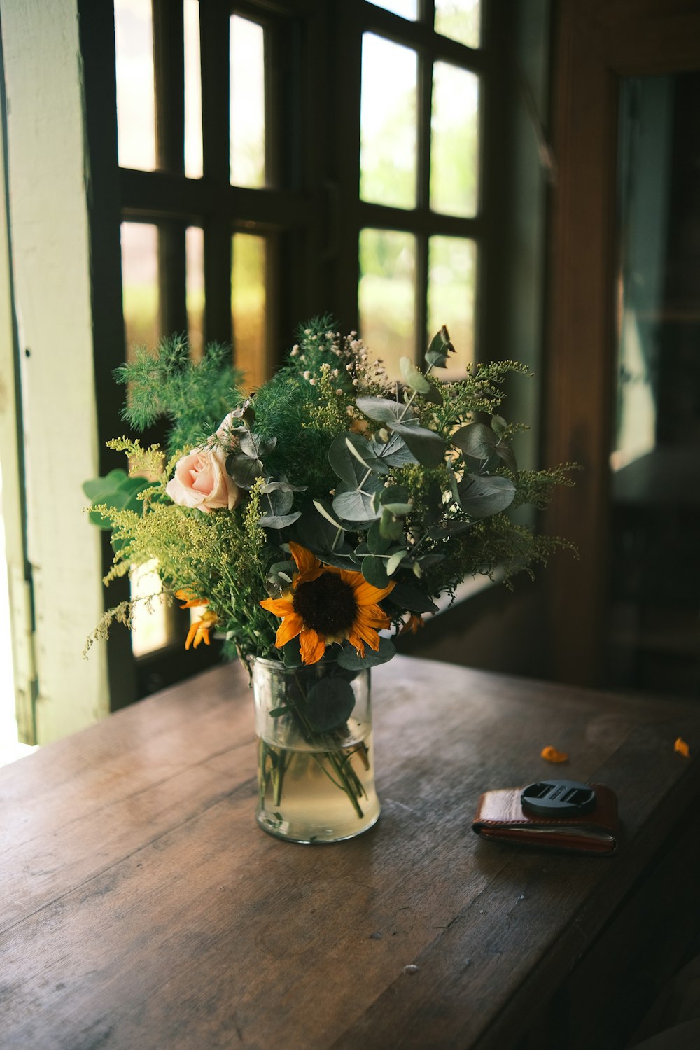 a vase filled with flowers sitting on top of a wooden table