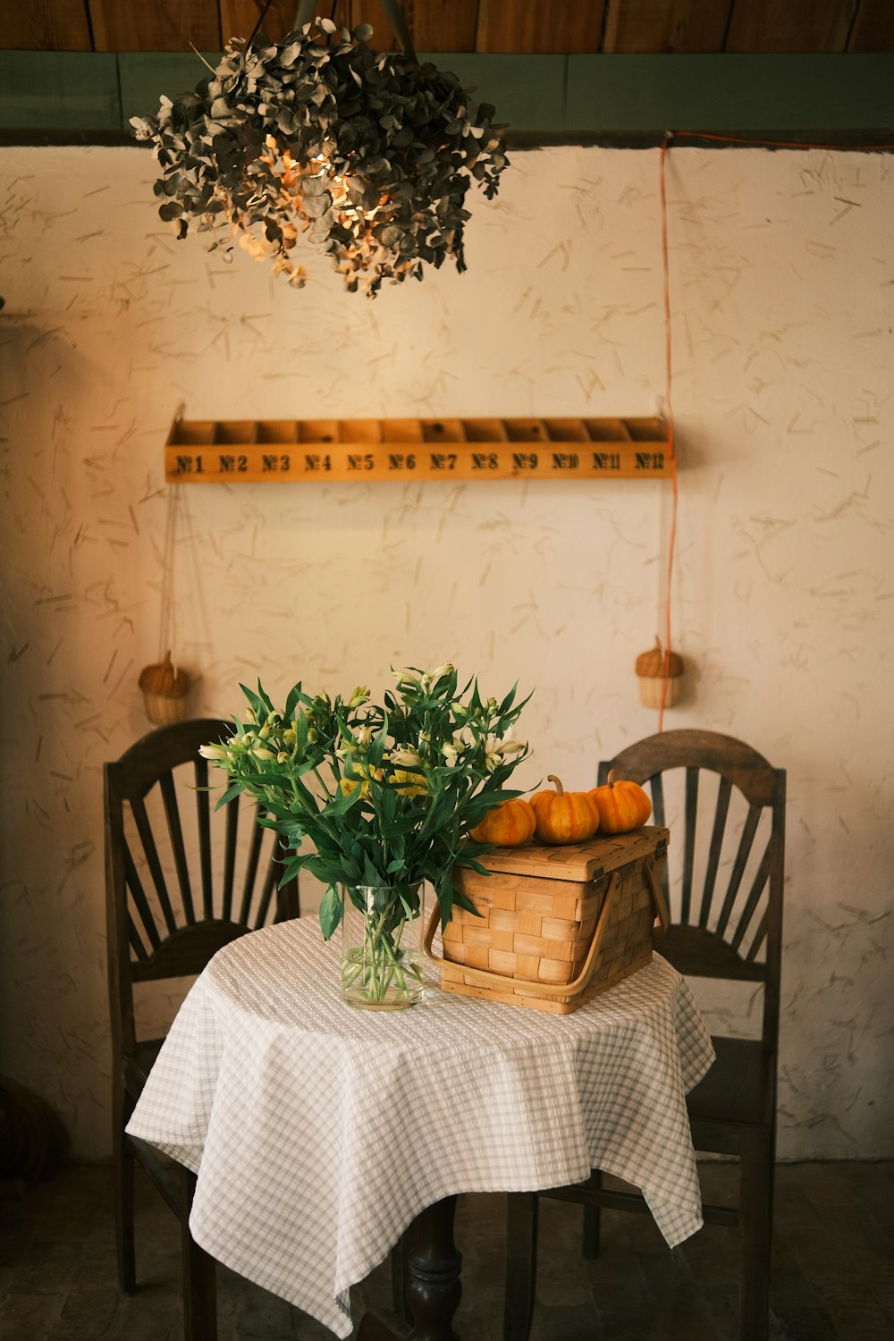 a table with a basket of pumpkins on top of it