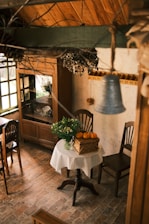 A cozy kitchen scene featuring a rustic wooden table set with colorful plates, bowls, and a sharp chef's knife.