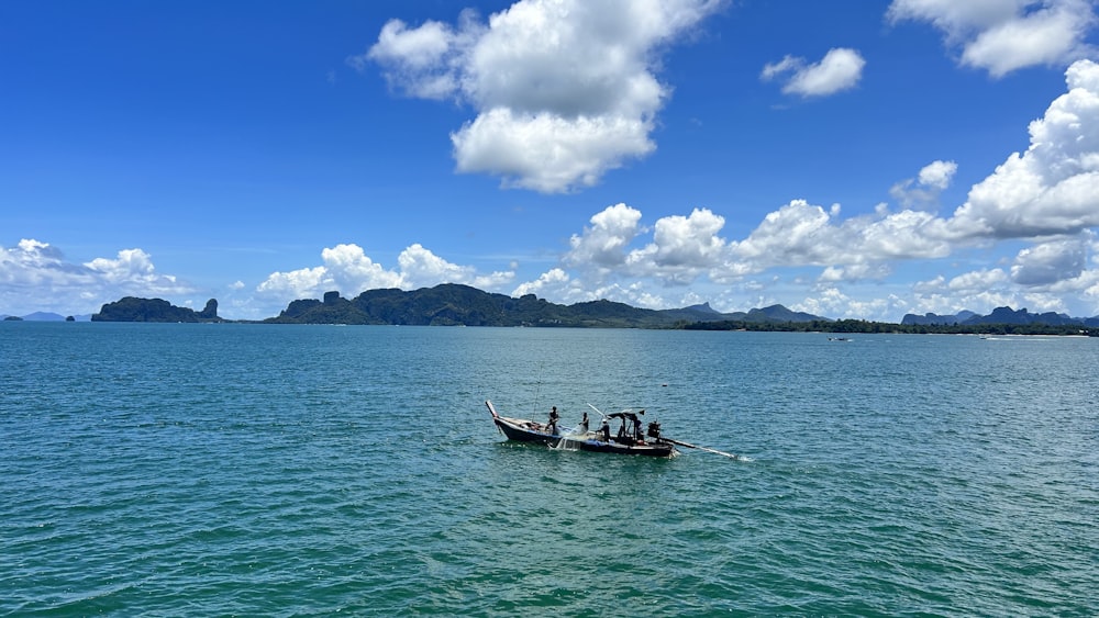 a group of people in a small boat on a large body of water