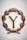 A large rusty metal letter Y is encircled by a laurel wreath made of the same material. The wreath features detailed leaves and is placed on a light marble surface, giving a classic and antiquated appearance.