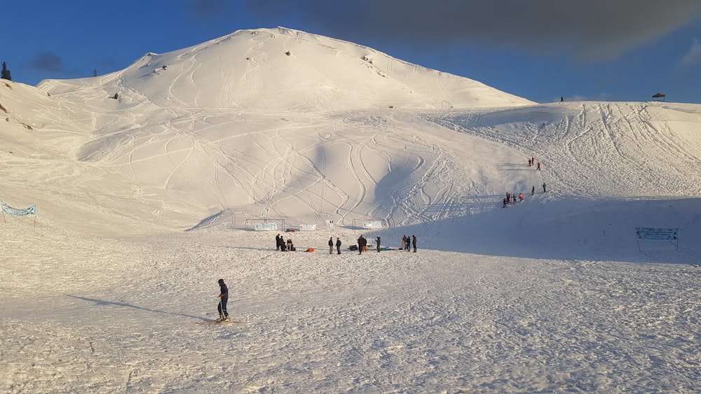 a group of people standing on top of a snow covered slope