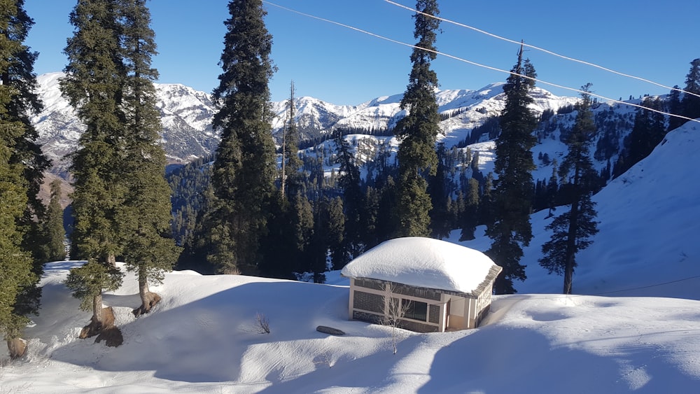 a snow covered mountain with a small building in the middle of it