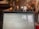 A laptop screen displaying a webpage is in the foreground, within a cozy cafe setting. The background shows a rustic interior with exposed brick walls, potted plants, and soft lighting. Patrons are seated at tables, engaged in conversation, creating a relaxed atmosphere.