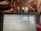 A laptop screen displaying a webpage is in the foreground, within a cozy cafe setting. The background shows a rustic interior with exposed brick walls, potted plants, and soft lighting. Patrons are seated at tables, engaged in conversation, creating a relaxed atmosphere.