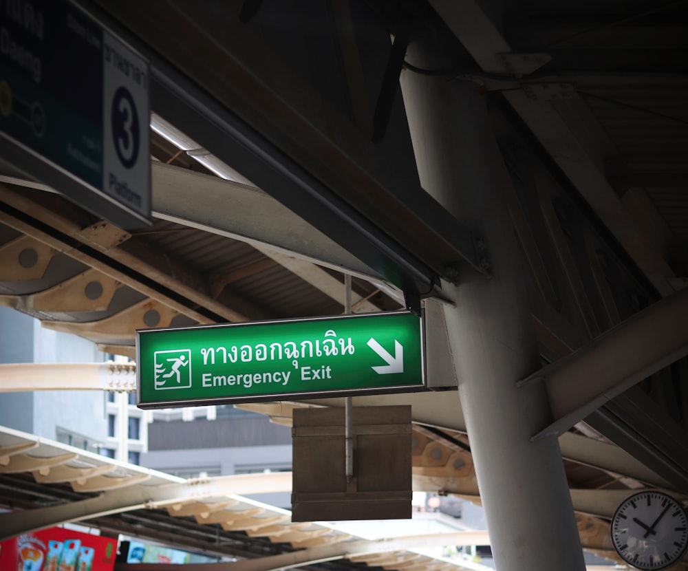 a green street sign hanging from the side of a building