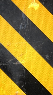Diagonal stripes in alternating black and yellow pattern are seen, likely used as a caution or warning sign. The surface appears textured with some signs of wear.