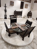 Classic wooden chairs with intricate carvings arranged around a round table.