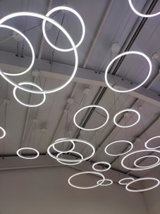 A ceiling with multiple circular LED light fixtures suspended at various heights, creating a modern and artistic appearance.