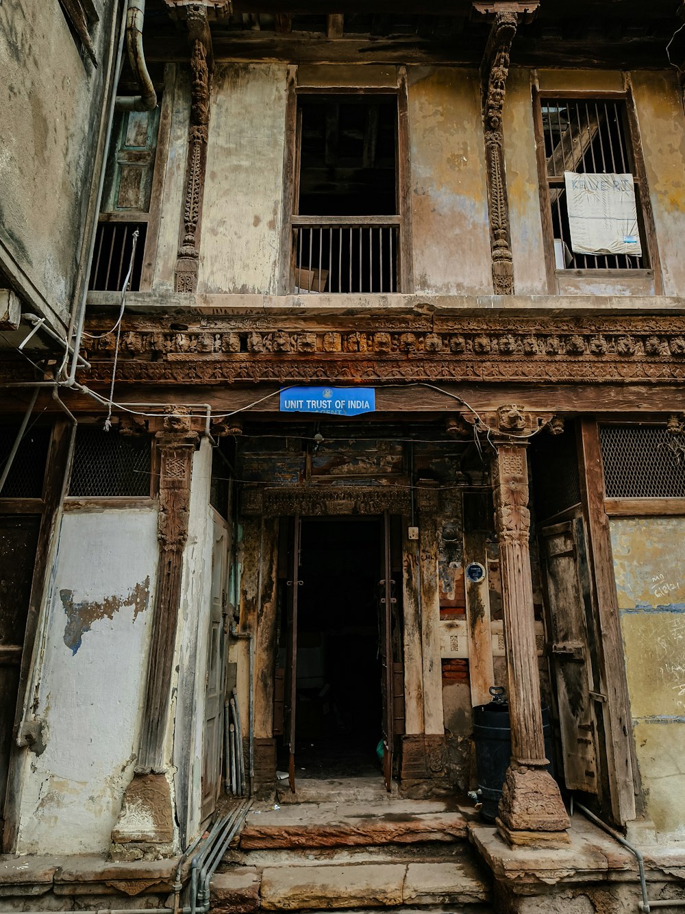 an old run down building with a blue sign on it