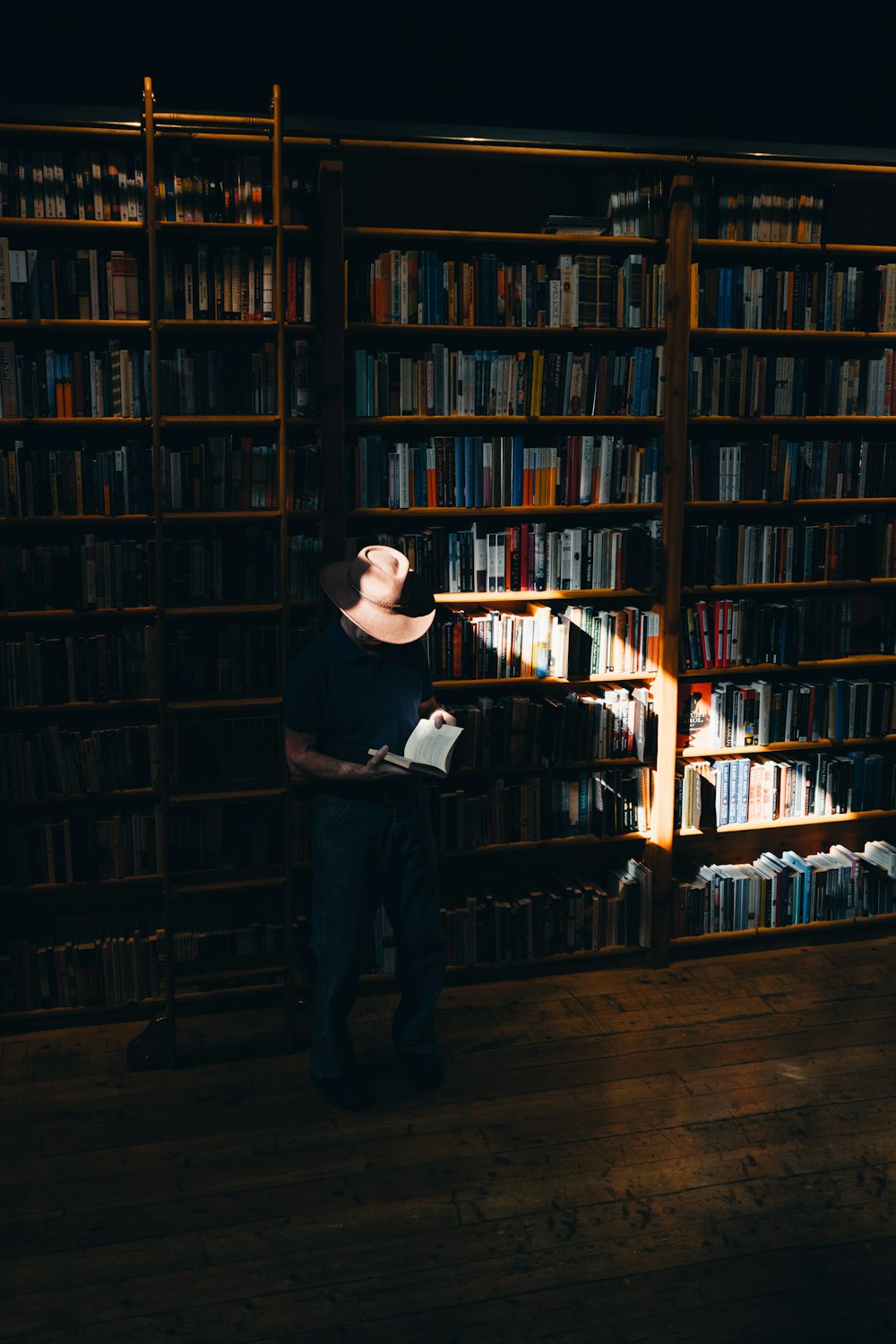 um homem parado em frente a uma estante de livros cheia de livros