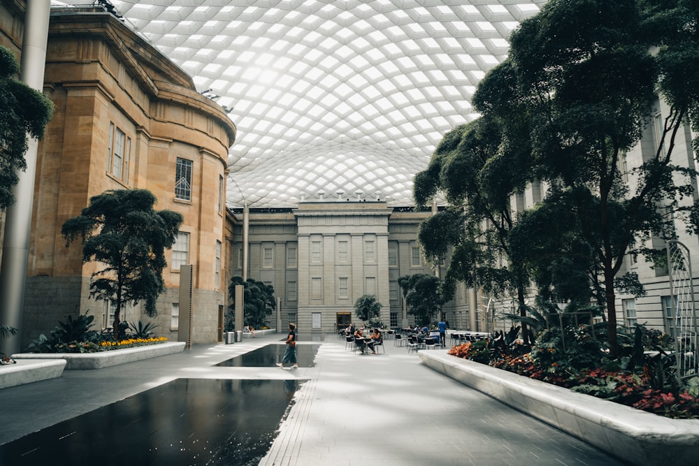 a building with a glass roof and a pond inside of it