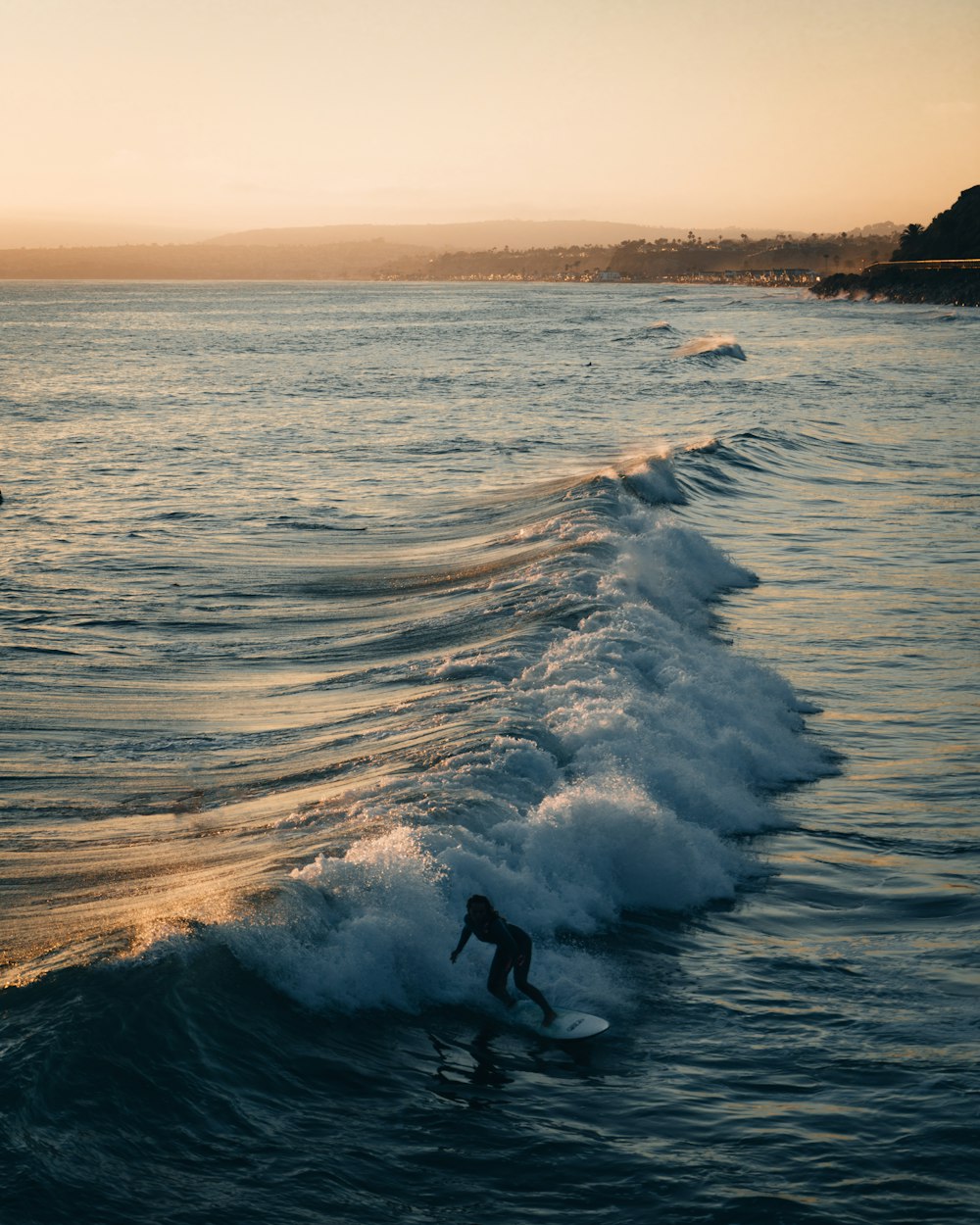 a man riding a wave on top of a surfboard