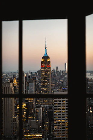 Evening view of Wall Street’s iconic buildings framed by a calm, inviting trading workspace.