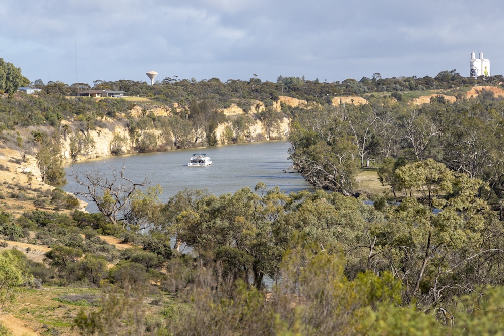 a boat traveling down a river surrounded by trees