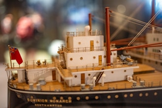 Blueprints and 3D models of a modern ship design displayed on a computer screen.