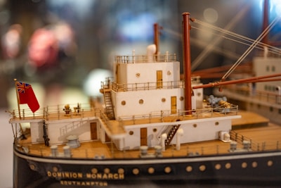 Blueprints and 3D models of modern ship designs on a designer's desk.