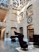 a large room with a piano and a clock on the wall