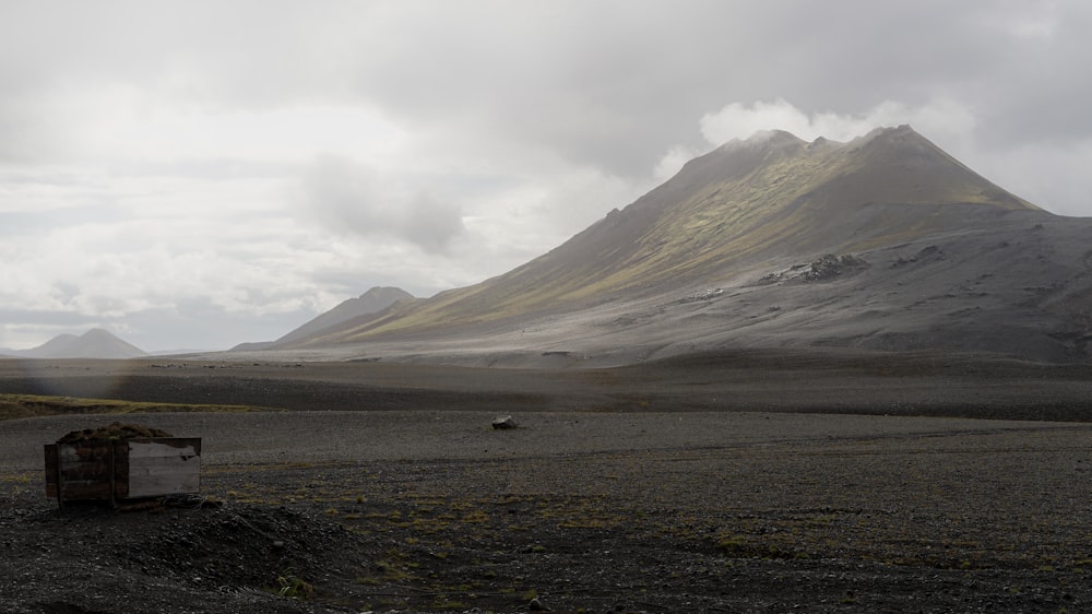 a mountain range with a small hut in the foreground