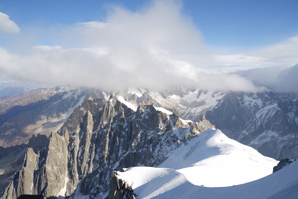 a view of a mountain range with a few clouds in the sky