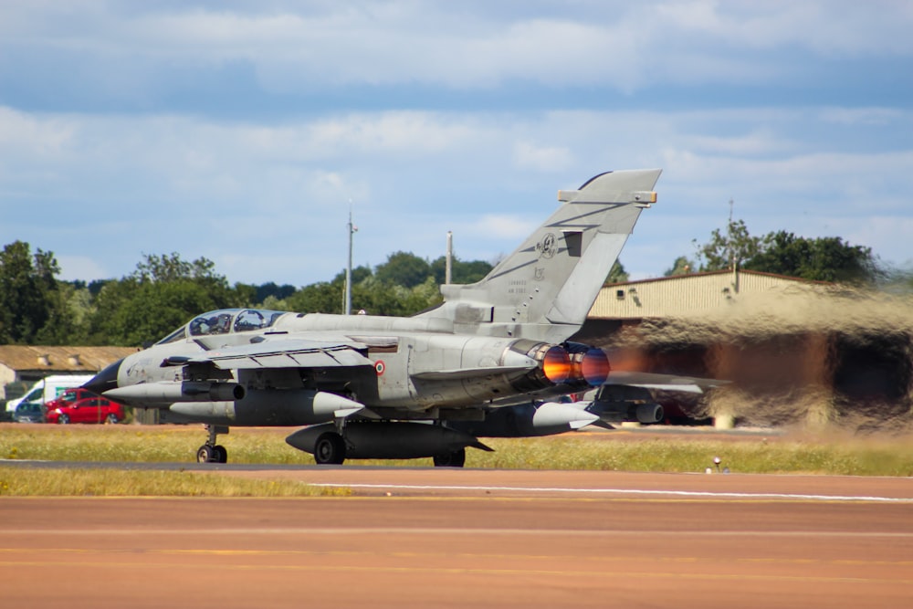 a fighter jet sitting on top of an airport runway