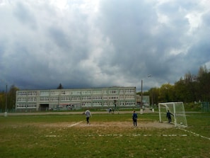 A lively outdoor sports activity with students playing football on the school field.