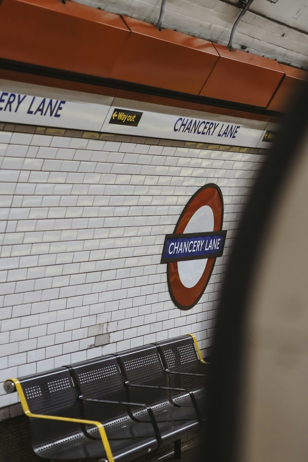 a subway station with benches and a sign on the wall