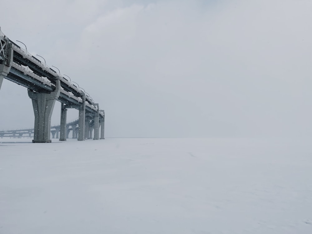 a bridge that is in the middle of a snowy field