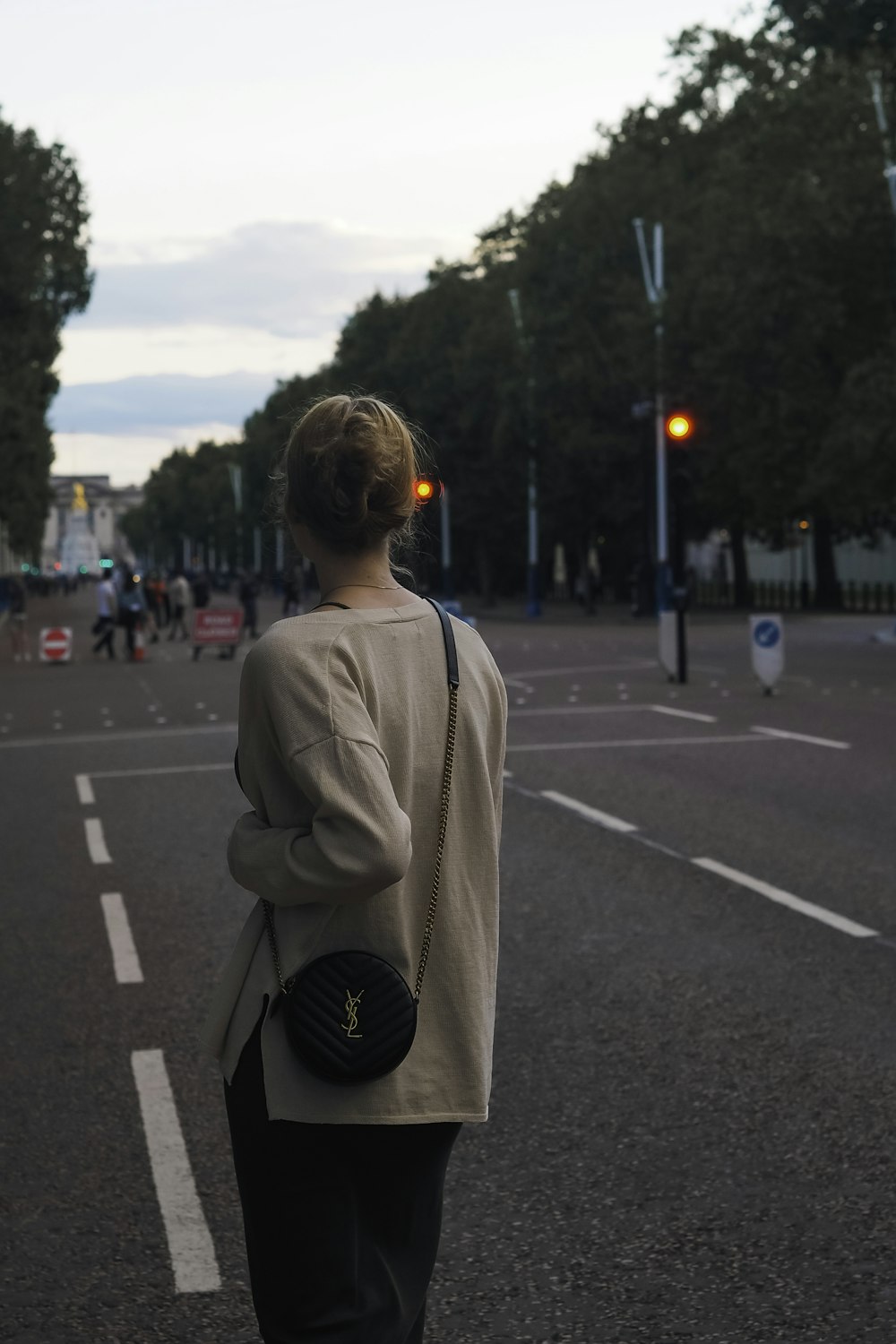 a woman walking down a street holding a purse