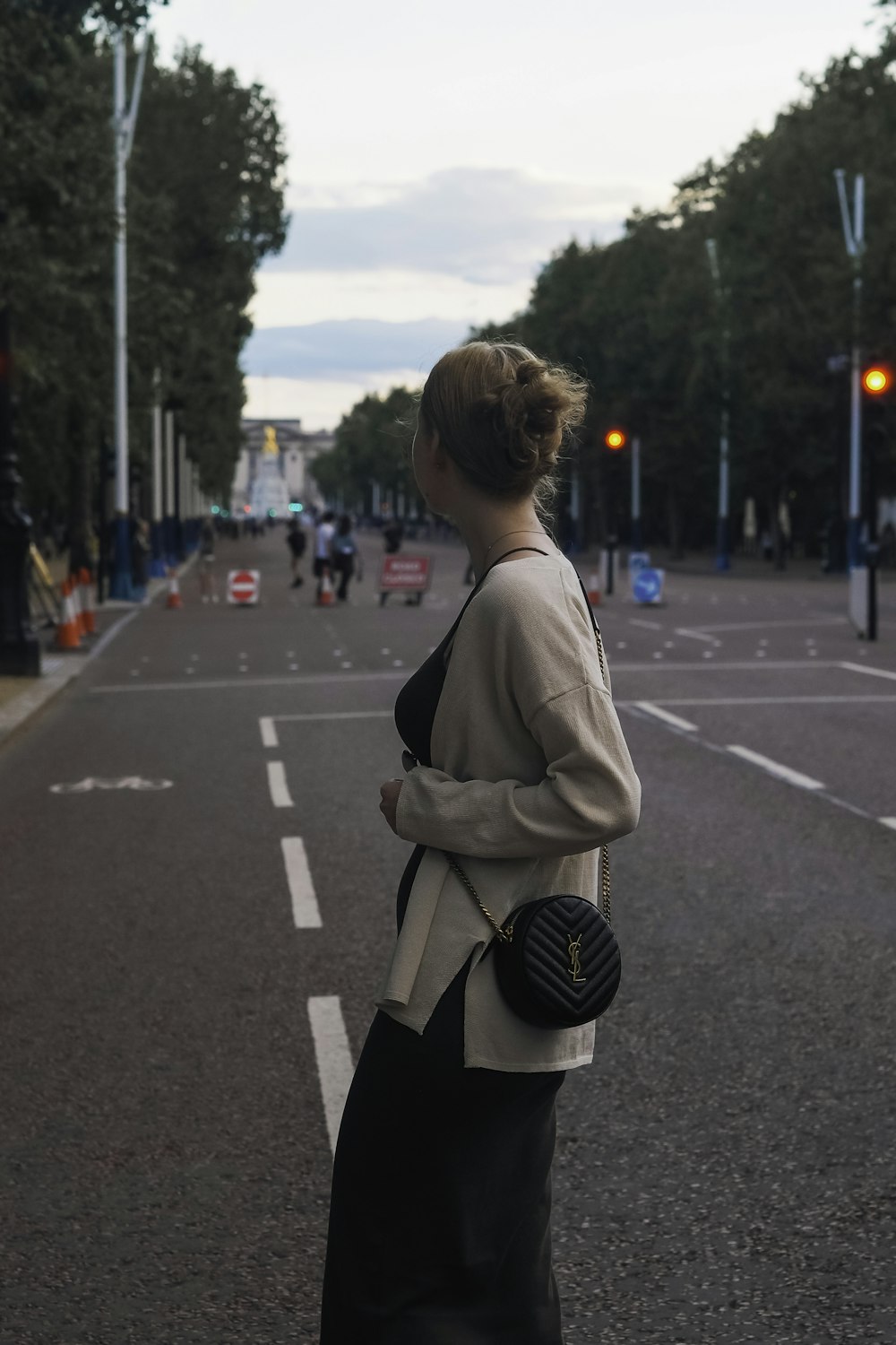 a woman standing on the side of a road