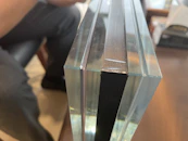 Close-up of a skilled technician carefully cutting a large glass pane with precision tools