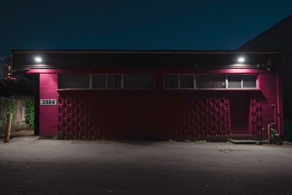 a red building with a number on it at night