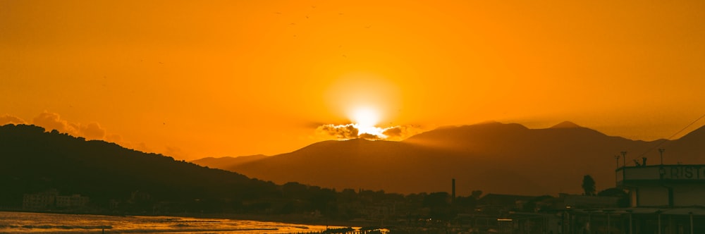 the sun is setting over a mountain range