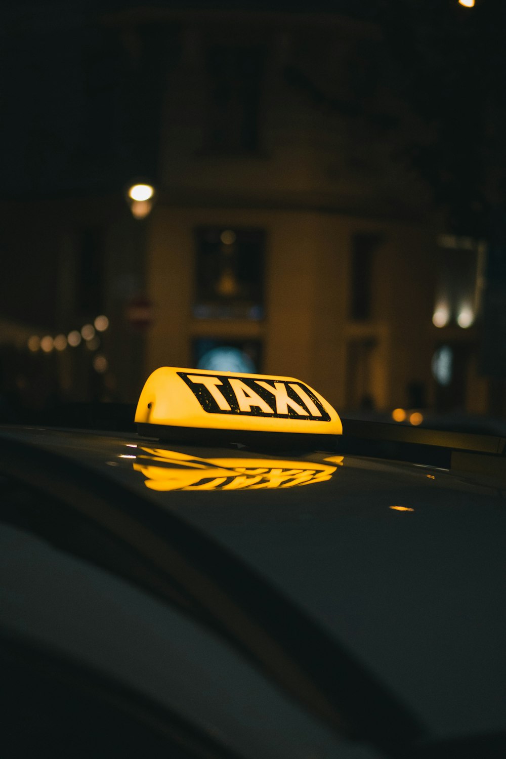 um táxi com um sinal de táxi amarelo em cima dele
