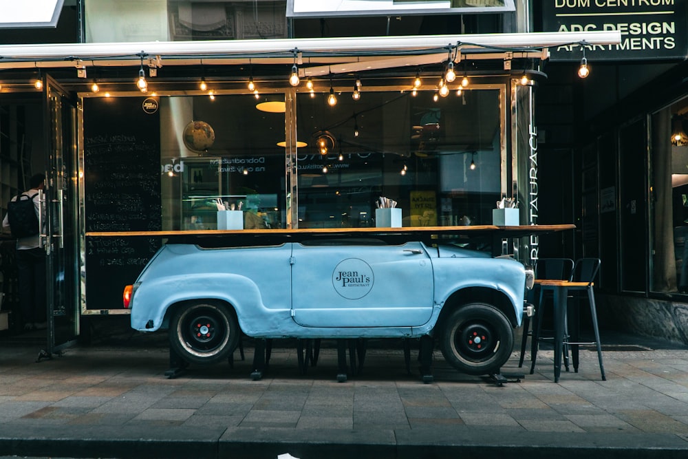 a blue car parked in front of a building