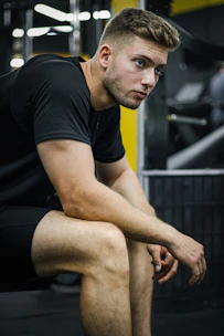 A focused young athlete smiling and preparing mentally before training, holding a Miozen device.