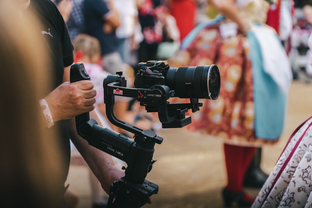 a person holding a video camera in front of a crowd